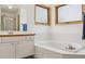 Bright bathroom featuring a soaking tub, a separate shower, dual windows, and white cabinets at 5282 Devon Ave, Castle Rock, CO 80104