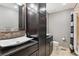 Modern bathroom featuring dual vessel sinks, dark wood cabinets, and a shower/tub combo at 5282 Devon Ave, Castle Rock, CO 80104
