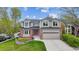Charming two-story home featuring a well-manicured lawn and a two-car garage with red brick and a red door at 5282 Devon Ave, Castle Rock, CO 80104