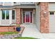 Close up of the entryway with red door, brick accents, and attractive wall decor at 5282 Devon Ave, Castle Rock, CO 80104