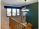 Well-lit hallway landing area featuring wood railings, an overhead light, and a window with a view at 5282 Devon Ave, Castle Rock, CO 80104