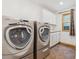 Functional laundry room featuring a washer, dryer, storage cabinets, countertop, and a window for natural light at 5282 Devon Ave, Castle Rock, CO 80104