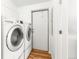 Bright laundry room with modern washer and dryer units and hardwood floors at 41575 E 88Th Ave, Bennett, CO 80102