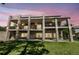 Exterior view of a multilevel home with expansive balconies and a lush green yard at 2595 S Harlan Ct, Lakewood, CO 80227
