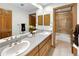 Bathroom featuring double sinks, wooden cabinets, and glass shower at 2595 S Harlan Ct, Lakewood, CO 80227