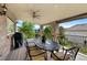 Relax on this inviting covered deck featuring an outdoor dining area, a ceiling fan, and a beautiful view at 2595 S Harlan Ct, Lakewood, CO 80227