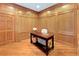 Cozy home office featuring wood-paneled walls, hardwood floors, and a desk with a chair at 2595 S Harlan Ct, Lakewood, CO 80227