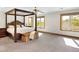 Bright main bedroom featuring a four-poster bed, large windows with scenic views, and comfortable carpet at 2595 S Harlan Ct, Lakewood, CO 80227