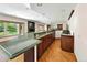 Finished basement wet bar with granite countertops, wood cabinets, and hardwood floors at 2595 S Harlan Ct, Lakewood, CO 80227