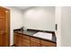 Functional wet bar with wood cabinets and sink providing convenience for cleaning and hobbies at 2595 S Harlan Ct, Lakewood, CO 80227