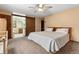 Main bedroom with carpeted floor, king-size bed, and barn door to bathroom at 9724 E Villasur Ct, Parker, CO 80134