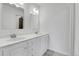 Bathroom featuring dual sinks, white cabinets, and modern fixtures at 12341 E Cedar Cir, Aurora, CO 80012