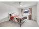 Cozy bedroom with a metal frame bed, ceiling fan, and natural light from the window at 12341 E Cedar Cir, Aurora, CO 80012