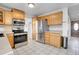 Kitchen with oak cabinets, a tiled floor, stainless steel appliances, and ample storage at 12341 E Cedar Cir, Aurora, CO 80012