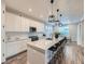 Modern kitchen with white cabinets, an island with barstool seating, and stylish pendant lighting at 14687 Eudora St, Thornton, CO 80602