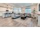Open living area with gray sofas, wood floors, and view into the kitchen, creating a connected living space at 14687 Eudora St, Thornton, CO 80602