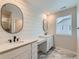 Bright main bathroom featuring dual sinks, ship lap wall, decorative mirrors and tile floors at 14687 Eudora St, Thornton, CO 80602