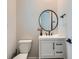 Modern powder room features round mirror and white vanity, providing a stylish and functional space at 14687 Eudora St, Thornton, CO 80602