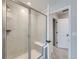 Bright shower featuring clear glass door, white tile, and a built-in bench with door to bathroom at 14687 Eudora St, Thornton, CO 80602