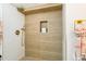 Spa-like shower with modern wood-look tile and gold accents at 2167 S Emerson St, Denver, CO 80210