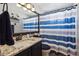 Bathroom featuring granite counters, toilet, and shower with blue and white striped curtain at 23634 Broadmoor Dr, Parker, CO 80138
