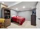Basement bedroom with red bed, grey walls, and neutral carpet at 23634 Broadmoor Dr, Parker, CO 80138