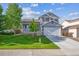 Charming two-story home with well-manicured lawn, inviting front porch, and attached two-car garage at 23634 Broadmoor Dr, Parker, CO 80138