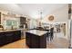 Spacious kitchen featuring island, granite countertops and ample storage space, leading to living area at 23634 Broadmoor Dr, Parker, CO 80138