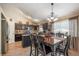 Elegant eat-in kitchen with dark cabinetry, granite countertops, and modern chandelier lighting at 23634 Broadmoor Dr, Parker, CO 80138