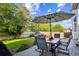 The patio offers outdoor dining with a table and chairs, an umbrella, and a view of the landscaped backyard at 23634 Broadmoor Dr, Parker, CO 80138