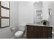 Stylish half bath with modern wood vanity, white herringbone backsplash, and decorative wall art at 4506 N Vrain St, Denver, CO 80212