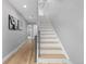 Bright stairway featuring modern white and wood stairs, a sleek railing, and neutral wall paint at 4506 N Vrain St, Denver, CO 80212