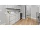 Modern wet bar featuring white cabinets, quartz countertop, a mini fridge, and hardwood flooring at 4506 N Vrain St, Denver, CO 80212