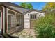 View of back exterior, showcasing sunroom, shed, and brick patio at 2518 S Patton Ct, Denver, CO 80219