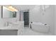 Bright bathroom featuring a dual sink vanity, shower, and modern soaking tub at 2518 S Patton Ct, Denver, CO 80219