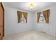 Bright bedroom featuring neutral carpet, two windows, and golden curtains at 2518 S Patton Ct, Denver, CO 80219