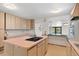Bright kitchen with a cooktop island and a pass through to an adjacent living area at 2518 S Patton Ct, Denver, CO 80219