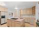 Bright kitchen featuring a cooktop island, light wood cabinetry, and pink countertops at 2518 S Patton Ct, Denver, CO 80219
