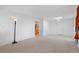 Open-concept living room with neutral carpet, white walls, and a view into the adjoining kitchen space at 2518 S Patton Ct, Denver, CO 80219