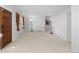 Spacious living room with bright white walls, neutral carpet, large window and a classic wooden front door at 2518 S Patton Ct, Denver, CO 80219