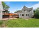 Backyard with green lawn, deck with dining, hot tub, and access to the rooftop deck at 2021 Eliot St, Denver, CO 80211
