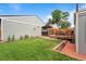 Backyard oasis featuring a deck with dining area, hot tub, and lush green lawn at 2021 Eliot St, Denver, CO 80211