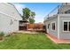 Backyard featuring a deck with dining area, hot tub, and lush green lawn at 2021 Eliot St, Denver, CO 80211