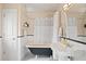 Elegant bathroom featuring a clawfoot tub, classic sink, and black and white tiled floor at 2021 Eliot St, Denver, CO 80211