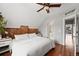 Bright bedroom featuring exposed brick accent wall, hardwood floors, and ensuite bathroom at 2021 Eliot St, Denver, CO 80211