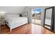 Sunny bedroom with hardwood floors, slider to balcony, and plenty of natural light at 2021 Eliot St, Denver, CO 80211