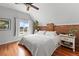 Inviting bedroom with exposed brick accent wall, hardwood flooring, and plenty of natural light at 2021 Eliot St, Denver, CO 80211