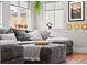Bright living room with a comfortable gray sectional couch and sunburst decorative wall art at 2021 Eliot St, Denver, CO 80211