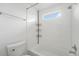 This bathroom features a sleek white tiled shower/tub combo with a convenient storage rack and a bright window at 1915 S Hannibal St # G, Aurora, CO 80013