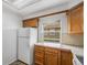 Cozy kitchen featuring oak cabinets, white appliances, and a window with natural light at 1915 S Hannibal St # G, Aurora, CO 80013